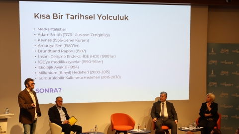 Panelde üç konuşmacı ve moderatör sahnede görülüyor 
