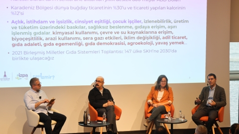 Panel konuşmacıları sahnede otururken görülüyor
