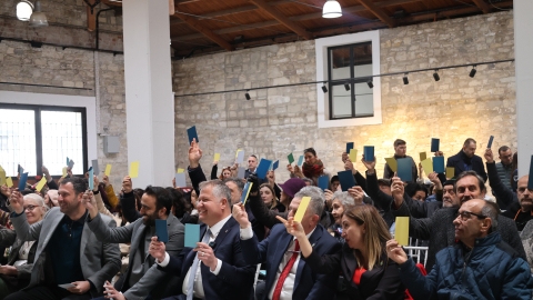 Panelde vatandaşlar ellerindeki farklı renklerdeki kartları kaldırarak tasarımları oylarken görülüyor