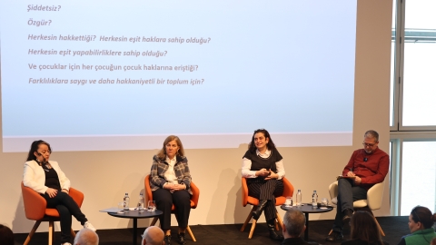 Panelistler ve moderatör sahnede otururken görülüyor