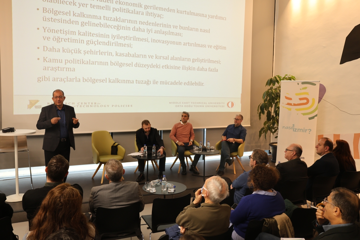 Panelistler ve moderatör sahnede görülüyor