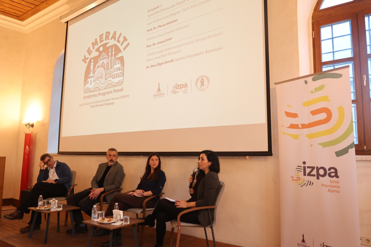 Panelistler sahnede otururken görülüyor
