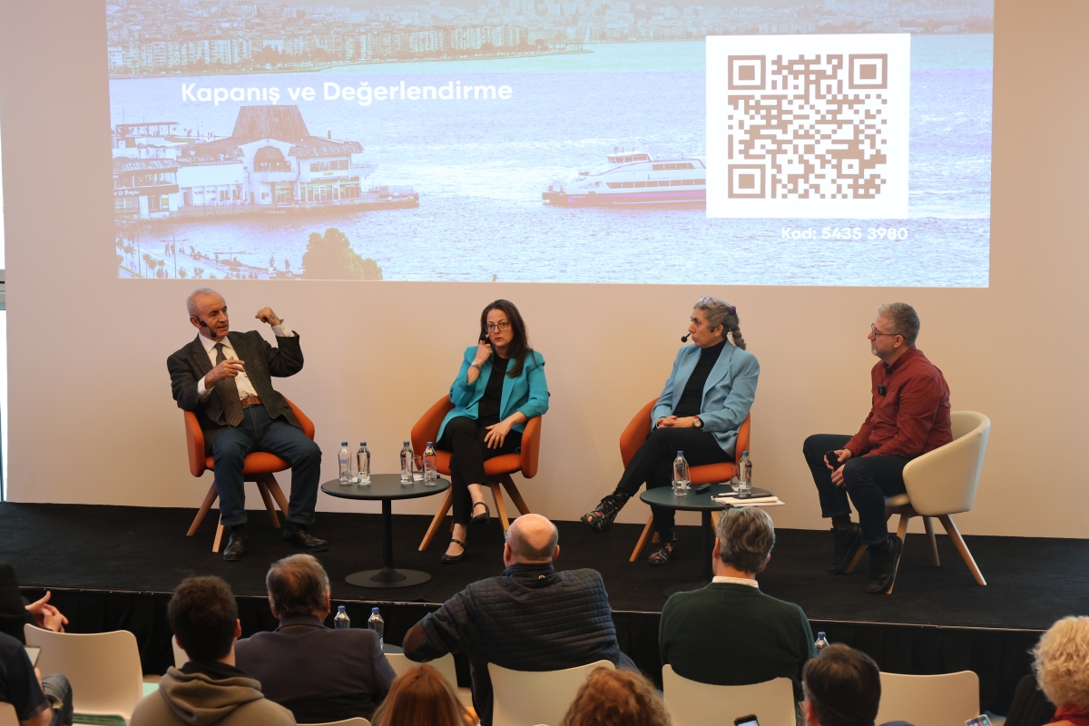 Panelistler ve moderatör sahnede otururken görülüyor